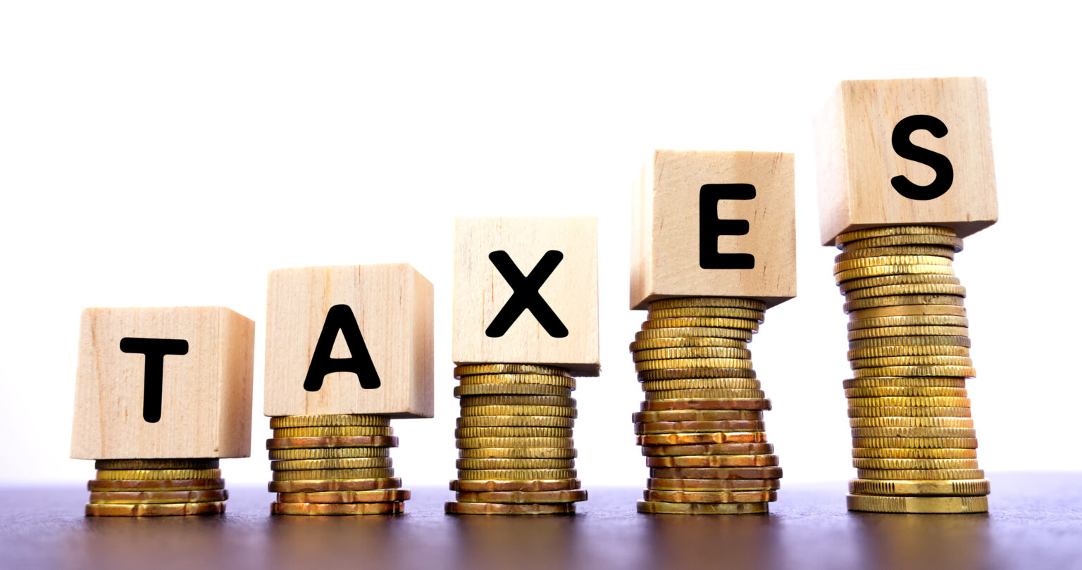 taxes word on wood block on top of coins stack